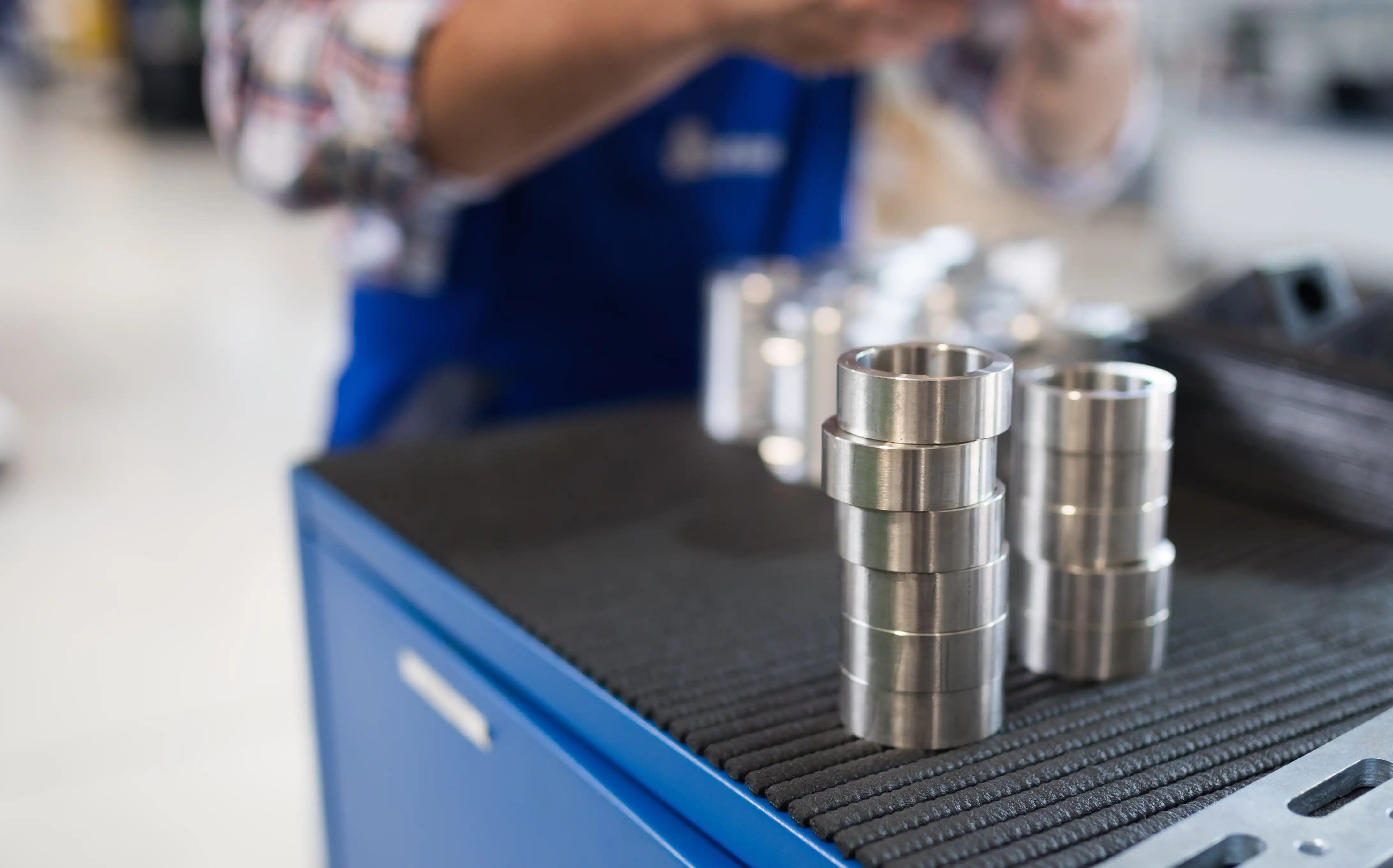 bearings-in-industry-factory-with-worker-in-backgr-2025-04-02-09-41-42-utc.webp